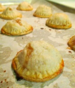 Miniature apple pies fresh out of the oven with a yummy golden crust.