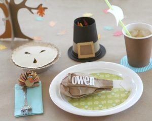 Cute table setting for kids Thanksgiving table. Pilgrim hat crayon holder, turkey leg placeholder, pretend pie, ship cup and turkey clip.
