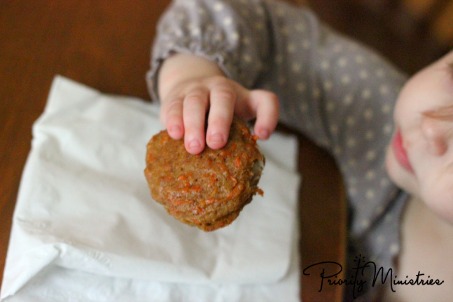 Little girl eating a carrot spice sandwich cookie.